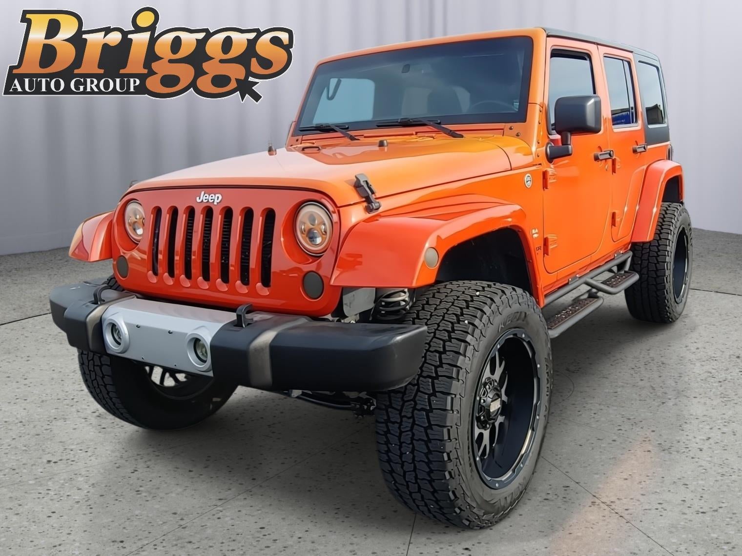 2015 Jeep Wrangler Unlimited Sahara in Sunset Orange Pearlcoat — front three-quarter view